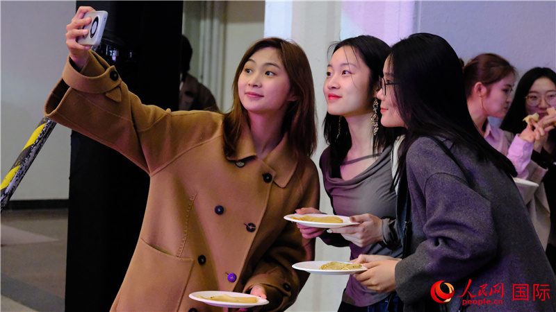 中國觀眾在現(xiàn)場品嘗“謝肉節(jié)”節(jié)日美食——煎薄餅。人民網(wǎng) 褚夢琦攝